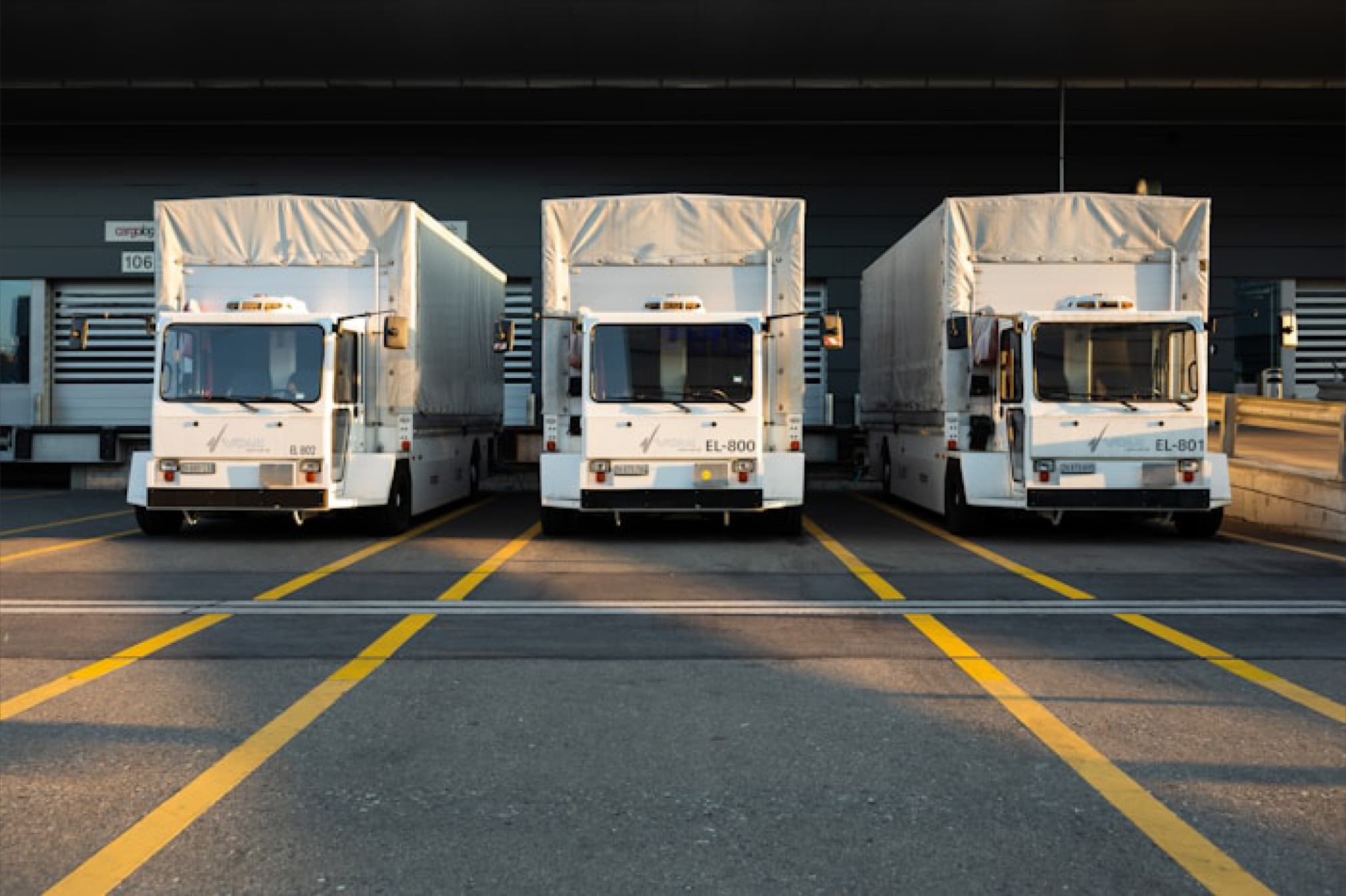 Electric fleet trucks parked at loading bays